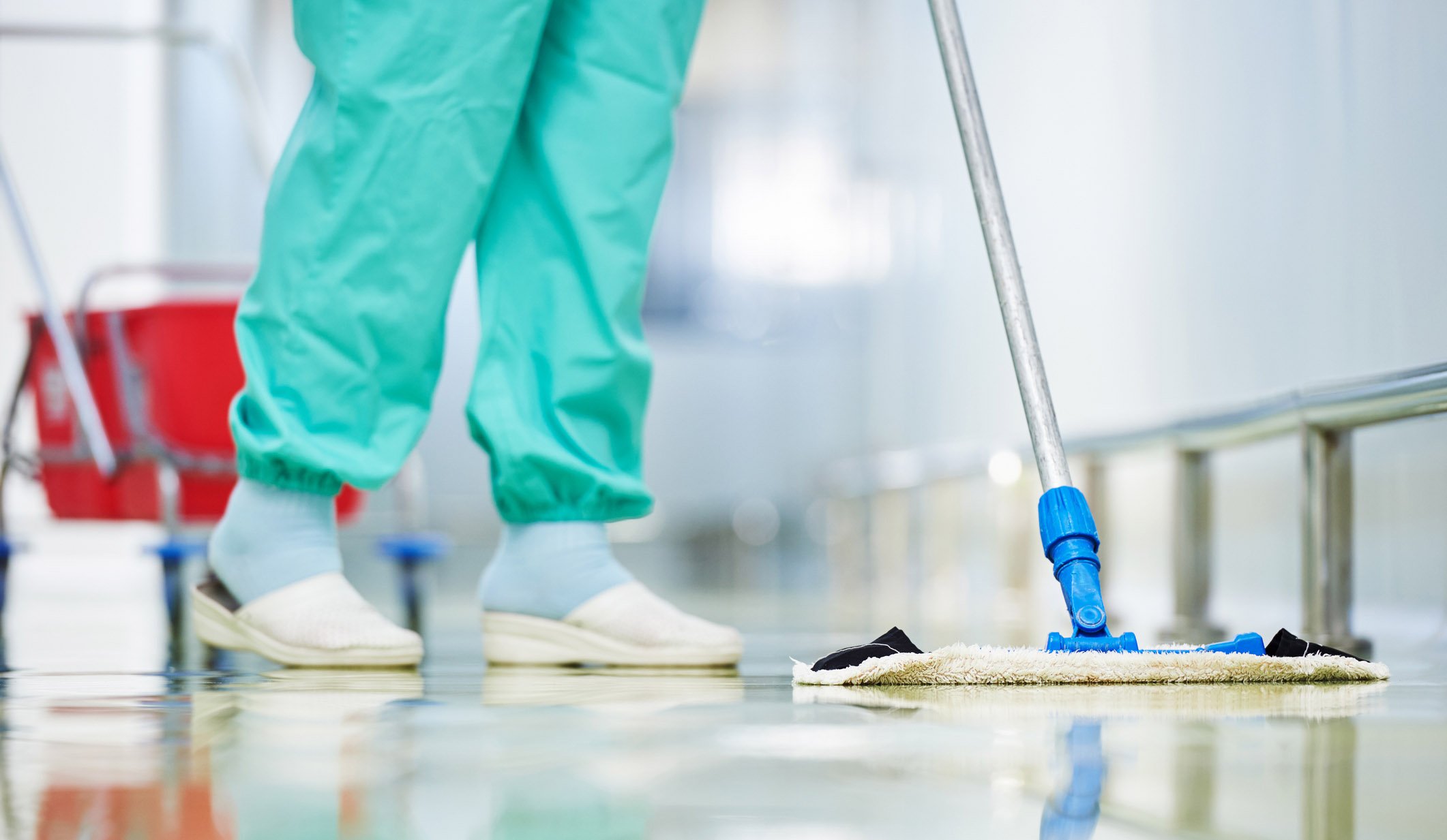 nurse cleaning a floor with a mop