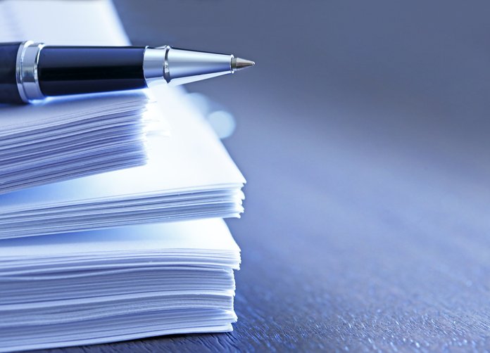 Silver Pen on top of a stack of papers.