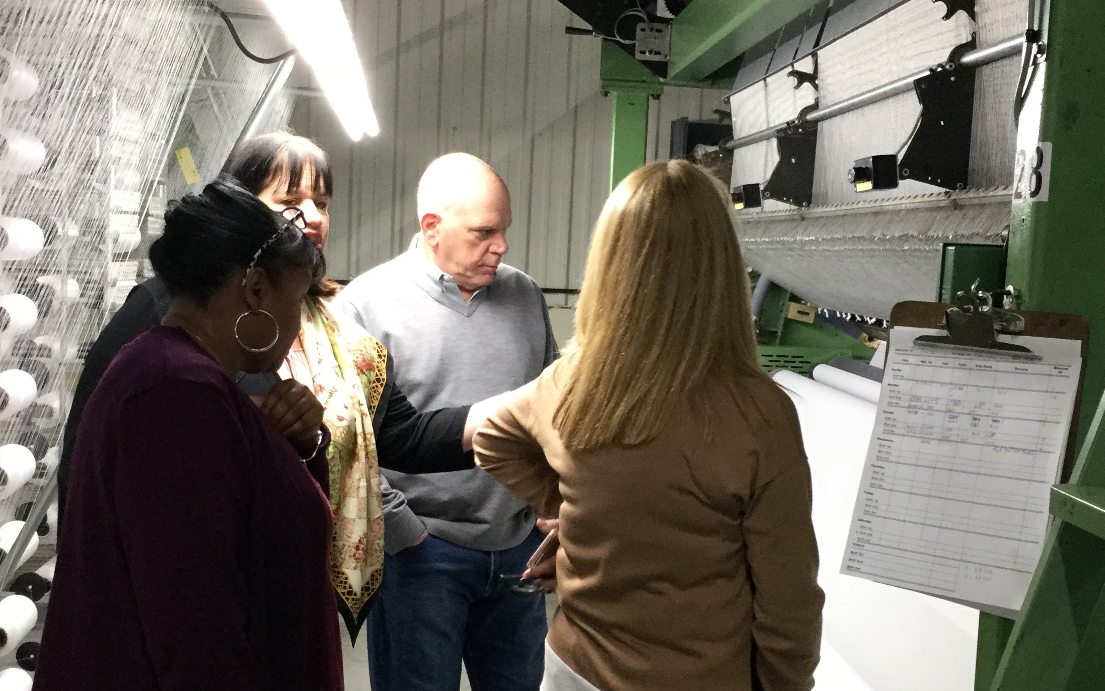 People reviewing a textile machine.